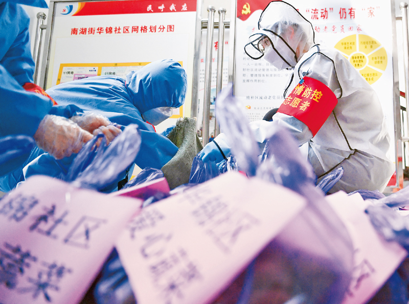 抗疫大战,惊心动魄,然而我们有党员、干部冲锋在前,有公安民警昼夜值守,有社区网格员随叫随到,有志愿者爱心接力……这些默默无闻的人们,守护着万家灯火,撑起每一座城市的生命线。图为2020年2月23日武汉市武昌区华锦社区的志愿者为社区居民分装爱心蔬菜。 新华社记者 程敏/摄